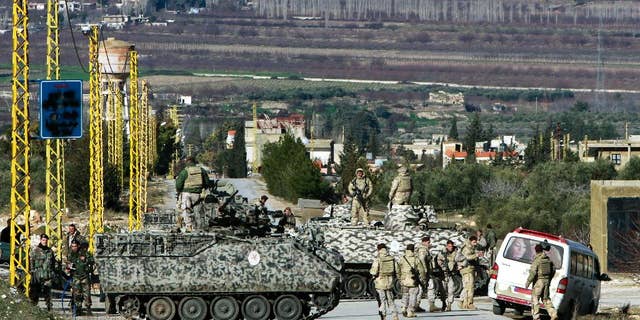 FILE - In this Saturday, Feb. 2, 2013 file photo, Lebanese army soldiers search civilians at a checkpoint for the entrance of Arsal, a Sunni Muslim town near the Syrian border in eastern Lebanon. A suicide bomber driving an explosives-laden car targeted a Lebanese army checkpoint near the Syrian border on Saturday, March 29, 2014, killing and wounding several soldiers, Lebanon's official news agency reported. (AP Photo/Bilal Hussein, File)