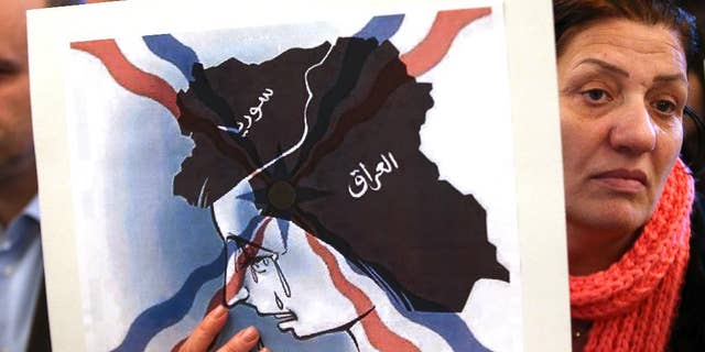 Thursday, Feb. 26, 2015: An Iraqi Assyrian woman who fled from Mosul to Lebanon holds a placard depicting the map of Iraq and Syria, during a sit-in for abducted Christians in Syria and Iraq, at a church in Sabtiyesh area east Beirut, Lebanon.