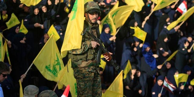 May 24, 2015: A Hezbollah fighter stands guard during a rally commemorating 'Liberation Day,' which marks the withdrawal of the Israeli army from southern Lebanon in 2000, in the town of Nabatiyeh, Lebanon. (AP Photo/Mohammed Zaatari)
