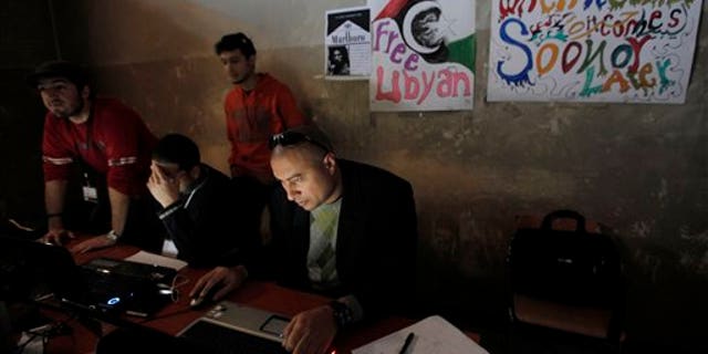 March 7:In this file photo, Libyan volunteers operate at the newly setup media center in what used to be a court house in Benghazi, Libya . The burnt-out building that once housed the high court has been transformed in the past three weeks into a bustling hub of civic life, home to a daily newspaper, a recording studio and a press center. (AP)