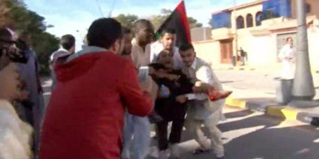 Nov. 15, 2015 - Image made from video shows an injured protester being carried away from the scene in Tripoli, Libya after militiamen attacked peaceful protesters demanding the disbanding of the country's rampant armed groups.