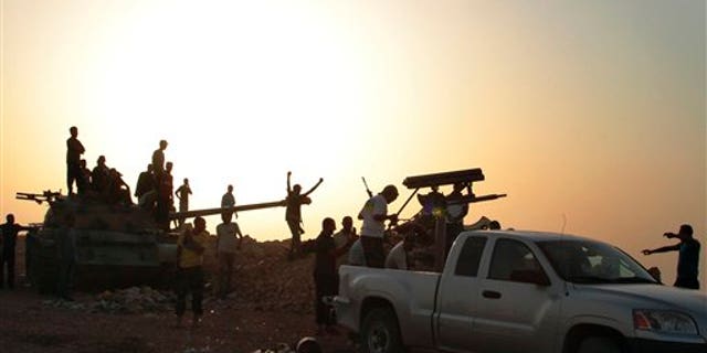 July 14: Libyan rebels gather around a captured tank in Kabaw, western Libya.