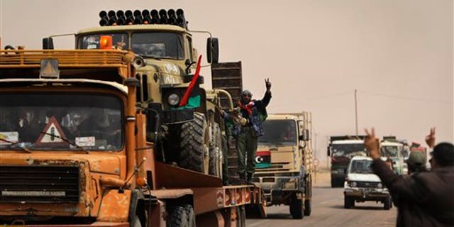 April 7: Libyan rebel fighters with vehicle-mounted multiple rocket launchers loaded on flatbed trucks head to the front line, from the western gate of Ajdabiya, Libya. Rebel fighters claimed NATO airstrikes blasted their forces Thursday in another apparent mistake that sharply escalated anger about coordination with the military alliance in efforts to cripple pro-Gadhafi forces. (AP)