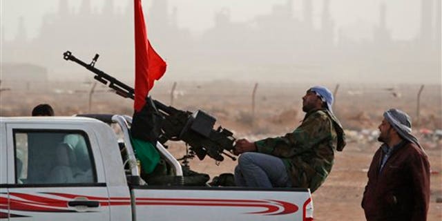 March 5: Libyan rebels who are part of the forces against Libyan leader Muammar al-Qaddafi guard outside the refinery after their victory in fighting against troops loyal to Qaddafi in the oil town of Ras Lanuf, eastern Libya.