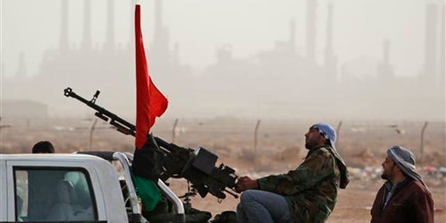 March 5: Libyan rebels who are part of the forces against Libyan leader Muammar al-Qaddafi guard outside the refinery after their victory in fighting against troops loyal to Qaddafi in the oil town of Ras Lanuf, eastern Libya.
