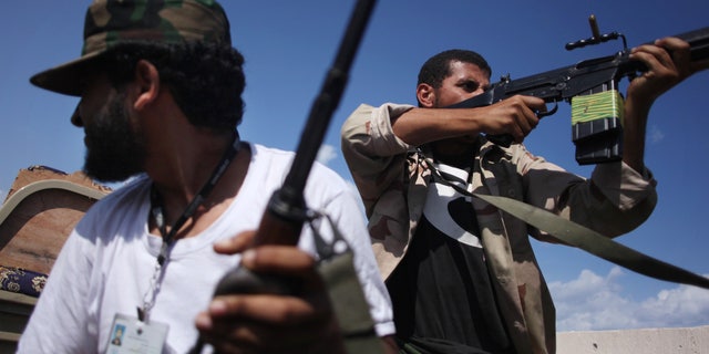 Oct. 18, 201:  Revolutionary fighters fire at Qaddafi loyalists in downtown Sirte, Libya.