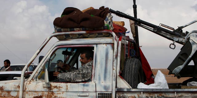 A Libyan rebel passes through the western gate of Ajdabiya, Libya on Friday, April 1, 2011. The western gate is closed for journalists and civilians trying to reach the front line of the conflict in Libya.