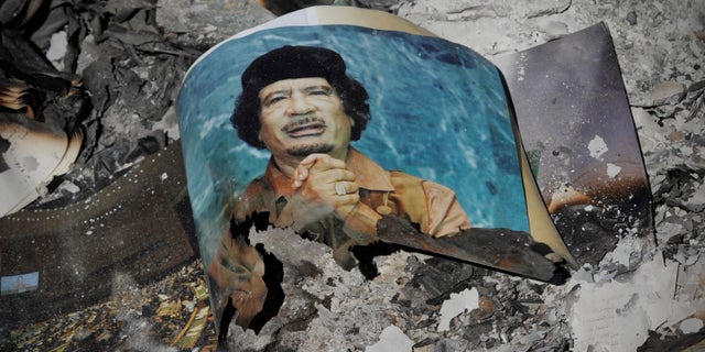 A picture of Libya's ousted leader Muammar Qaddafi is seen in the ashes in downtown Sirte, Libya, Wednesday, Oct. 12, 2011.