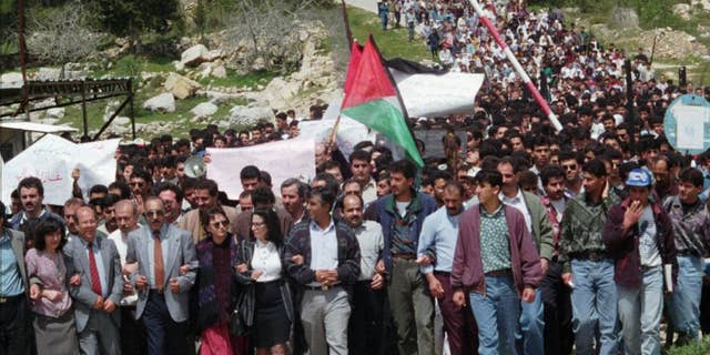 FILE - In this April 1, 1996 file photo, Palestinian protesters march from the Bir Zeit University in the West Bank. The expulsion of an Israeli journalist on Sept. 23, 2014, from an academic conference hosted by a top Palestinian university has unleashed a fierce debate about academic freedom in the West Bank and is shining a spotlight on the apparent radicalization of some young Palestinians who are disillusioned by years of failed peace efforts and have grown up with little contact with Israelis. (AP Photo/Sanad Sahlieh, File)