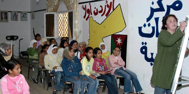 This Nov. 16, 2006 photo provided by the Peace Corps, Andrea Girard from Coulterville, CA., teaches English at an all girls school in Jordan. The Peace Corps said Saturday, March 7, 2015, it is temporarily suspending its program in Jordan because of the “regional environment,” highlighting growing security concerns among some foreigners after Jordan raised its profile in the battle against Islamic State militants. The Peace Corps said 37 volunteers had been working with local communities on youth development, and that all volunteers have left Jordan. (AP Photo/Peace Corps)