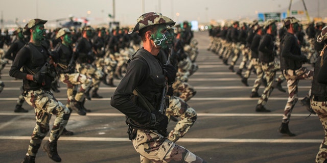 Sept. 17, 2015: Saudi security forces, whose faces display the word "Decisive" take part in a military parade in preparation for the annual Hajj pilgrimage in Mecca, Saudi Arabia.