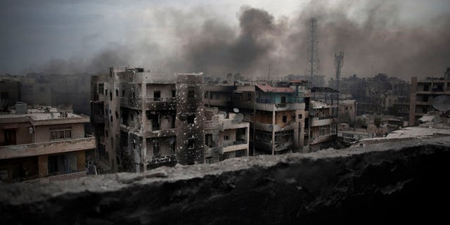 FILE - In this Tuesday, Oct. 2, 2012 file photo, smoke rises over Saif Al Dawla district, in Aleppo, Syria. Residents in the rebel-held districts of Aleppo have a reprieve from the incessant bombings by Syrian government warplanes and the promise of an end to the crippling siege that has left produce stalls bare. (AP Photo/ Manu Brabo, File)