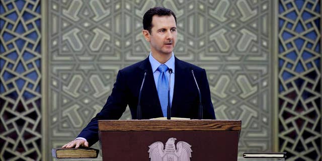 FILE - In this Wednesday, July 16, 2014 file photo released by the Syrian official news agency SANA, Syria's President Bashar Assad is sworn for his third, seven-year term, in Damascus, Syria. Assad said in remarks published Wednesday that U.S.-led airstrikes targeting Islamic State group militants in his country are neither serious nor efficient, claiming they have failed to produce any tangible results. (AP Photo/SANA, File)