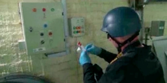 Oct. 8, 2013 - FILE image made from video broadcast on Syrian State Television shows a chemical weapons expert taking samples at a chemical weapons plant at an unknown location in Syria. The dismantling of Syria's chemical weapons stockpile is under way, but the mission faces multiple challenges.