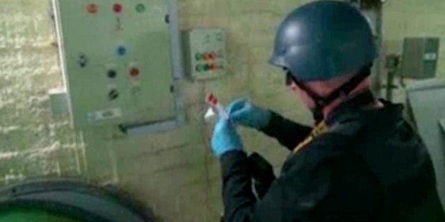 Oct. 8, 2013 - FILE image made from video broadcast on Syrian State Television shows a chemical weapons expert taking samples at a chemical weapons plant at an unknown location in Syria. The dismantling of Syria's chemical weapons stockpile is under way, but the mission faces multiple challenges.