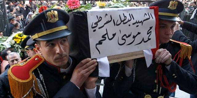 Jan. 7: Syrian police honor guards carry the coffin of one of 11 Syrian police officers who were killed in an explosion in the Midan neighborhood on Friday, during a mass funeral procession at Al-Hassan mosque, in Damascus, Syria.