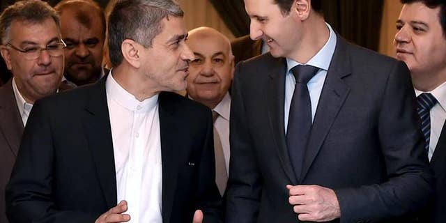 This photo released on the official Facebook page of the Syrian Presidency, shows Syrian President Bashar Assad, right, meeting with Iranian minister of economy and financial affairs, Ali Tayebnia, left, in Damascus, Syria, Monday, March 16, 2015. Assad said to Iranian TV "only the Syrian people can decide his future adding that Damascus is not concerned about statements made abroad." (AP Photo)