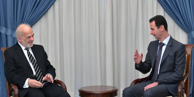 In this photo released by the Syrian official news agency SANA, Syrian president Bashar Assad, right, speaks with Iraqi Foreign Minister Ibrahim al-Jaafari, left, in Damascus, Syria, Tuesday, March. 24, 2015. Al-Jaafari said they discussed “Syrian and Iraqi issues, and the common dangers that threaten our security.” (AP Photo/SANA)