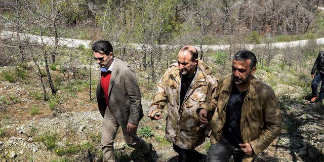 In this picture released by the Syrian National Coalition Media Office, Ahmad al-Jarba, center, the head of the delegation of the Syrian National Coalition, who wears a camouflage jacket during his rare visit to the front lines where the rebels fighting against the Syrian government troops, in the coastal province of Latakia, Syria, Tuesday April 1, 2014. Al-Jarba visited Kassab during his trip to the Latakia’s front lines, the Western-backed Syrian National Coalition said in a statement. (AP Photo / The Syrian National Coalition Media Office)