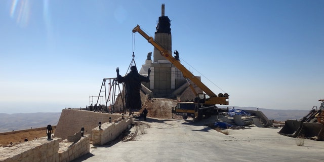 Oct. 14, 2013: This photo provided by the St. Paul's and St. George's Foundation shows workers preparing to install a statue of Jesus on Mount Sednaya, Syria.