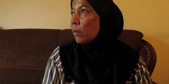 In this July 14, 2014 photo, Syrian refugee Umm Jamil looks on at her house in Halba town, northern Lebanon. Jamil, who takes care of her 19-year-old disabled son, said she was falsely accused of prostitution after Lebanese police confused her for another suspected prostitute in her building. Her brief detention left her feeling humiliated and wanting to leave Lebanon, where she said Syrian women are often seen as being sexually promiscuous. (AP Photo/Diaa Hadid)