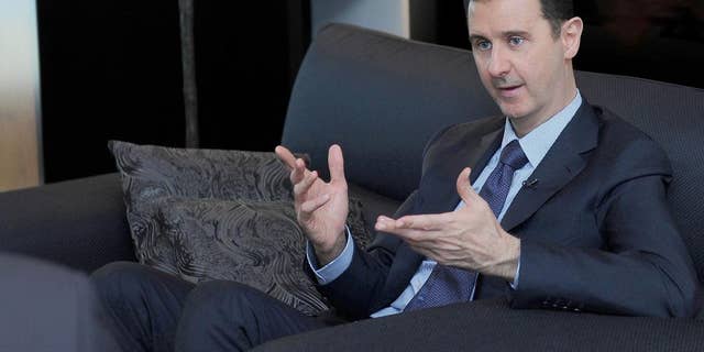 FILE - In this Monday, Aug. 26, 2013 file photo released by the Syrian official news agency SANA, Syrian President Bashar Assad gestures as he speaks during an interview with a Russian newspaper in Damascus, Syria. Assad said Thursday, March 6, 2014, that Russia's military takeover of Crimea reflects President Vladimir Putin's "wise policy" and his efforts to restore "security and stability" in Ukraine after an "attempted coup." (AP Photo/SANA, File)