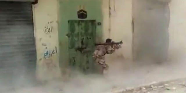 FILE - This Wednesday, May 29, 2013 file image made from video posted by Shaam News Network, which is consistent with other AP reporting, shows a Free Syrian Army fighter firing a rocket propelled grenade in Aleppo, Syria, targeting a Syrian regime stronghold. (AP Photo)