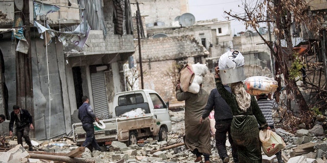 Dec. 11, 2012 - Syrian residents carry their belongings after their homes were damaged due to fighting between Free Syrian Army fighters and government forces in Aleppo, Syria.