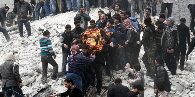 Feb. 3, 2013 - Syrian people carry a body after a government airstrike hit the neighborhood of Ansari, in Aleppo, Syria.