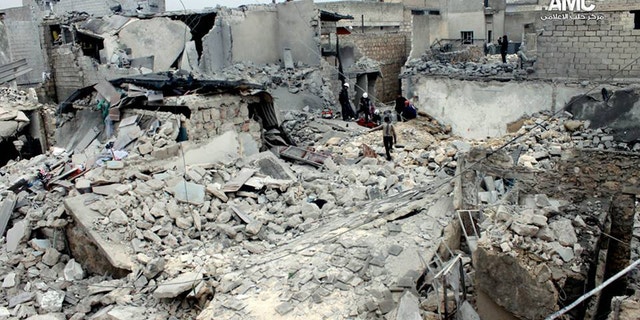 Jan. 23, 2014 - An anti-Bashar Assad activist group, Syrian residents and rescue workers check the rubble of houses damaged, attacked by the Syrian forces airplanes in Aleppo, Syria. (Aleppo Media Center, AMC)