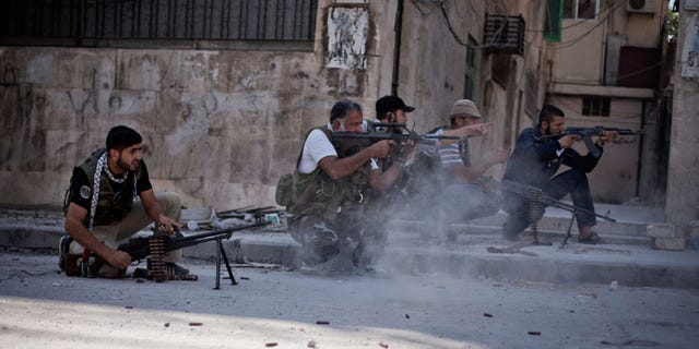 In this Saturday, Sept 8, 2012 photo, Free Syrian Army soldiers shoot their weapons towards Syrian Army positions in the Izaa district of Aleppo, Syria. Syrian activists say President Bashar Assad's regime pounded Aleppo with warplanes and artillery shelling Saturday as ground forces seeking to regain momentum in the country's largest city advanced on three neighborhoods. (AP Photo/Manu Brabo)