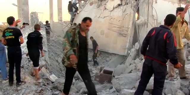 In this image taken from video obtained from Shaam News Network (SNN), which has been authenticated based on its contents and other AP reporting, Syrians dig through rubble of a building destroyed by a government airstrike as they search for survivors in Azaz, Syria, Friday, Sept. 28, 2012. A Syrian activist group, the Local Coordination Committees, said a Syrian warplane bombed the northern town of Azaz near the Turkish border, killing several people. (AP Photo/Shaam News Network SNN via AP video)