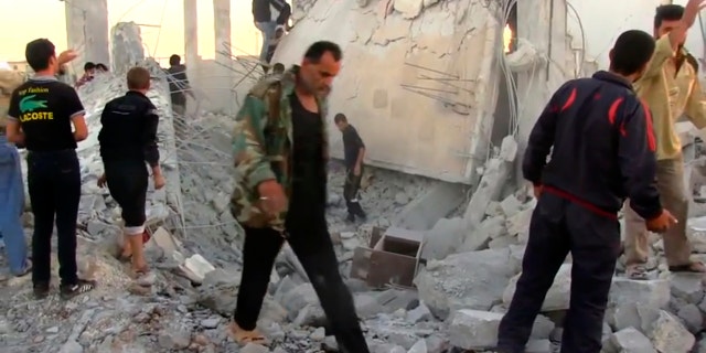 In this image taken from video obtained from Shaam News Network (SNN), which has been authenticated based on its contents and other AP reporting, Syrians dig through rubble of a building destroyed by a government airstrike as they search for survivors in Azaz, Syria, Friday, Sept. 28, 2012. A Syrian activist group, the Local Coordination Committees, said a Syrian warplane bombed the northern town of Azaz near the Turkish border, killing several people. (AP Photo/Shaam News Network SNN via AP video)