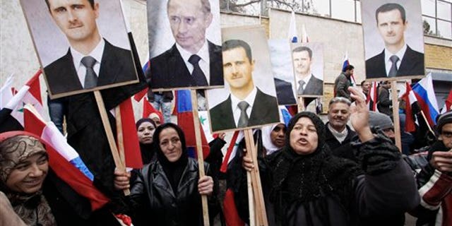 March 4: Syrians hold photos of Syrian President Bashar Assad and Russian Prime Minister Vladimir Putin during a pro-Syrian regime protest in front of the Russian Embassy in Damascus, Syria.