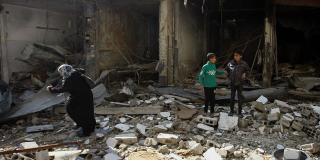 November 20, 2013: Syrian civilians look for undamaged furniture, clothes and food in their homes destroyed during the clashes between the Sunni-dominated Free Syrian Army and Syrian soldiers loyal to Syria's President Bashar Assad, supported by Iraqi and Lebanese Shiite fighters, in the town of Hejeira, which Syrian troops captured, in the countryside of Damascus, Syria. (AP Photo/Jaber al-Helo)