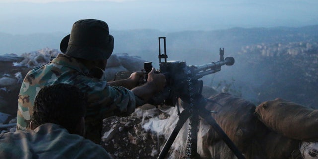 Oct. 10, 2015: Syrian army personnel fire a machine gun in Latakia province, about 12 miles from the border with Turkey, Syria.