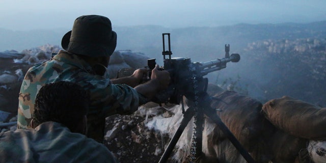 Oct. 10, 2015: Syrian army personnel fire a machine gun in Latakia province, about 12 miles from the border with Turkey, Syria.