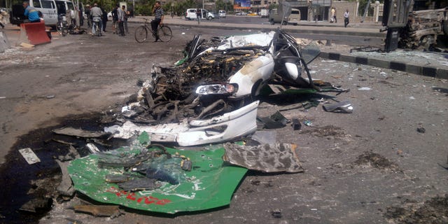 July 21, 2012: This citizen journalist image shows a destroyed car on a street damaged by tank treads after fighting between rebels and Syrian troops in the Yarmouk camp for Palestinian refugees in south Damascus, Syria.