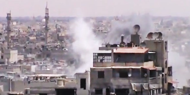 June 18, 2012: This image made from amateur video released by the Shaam News Network, purports to show smoke rising from buildings in Homs, Syria.
