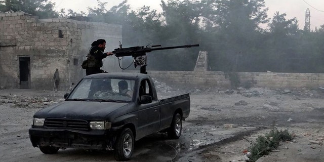 June 20, 2013 - Syrian rebel fires a heavy machine gun towards Syrian soldiers loyal to Syrian President Bashar Assad in Aleppo, Syria. (Citizen journalism image provided by Aleppo Media Center.)