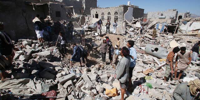 People search for survivors under the rubble of houses destroyed by Saudi-led airstrikes in Sanaa, Yemen, Friday, May 1, 2015. Saudi Arabia leads a coalition of mostly Sunni Arab countries conducting airstrikes against the rebels who have overrun the Yemeni capital, Sanaa, and forced the Western-backed president, Abed Rabbo Mansour Hadi, to flee the country. (AP Photo/Hani Mohammed)