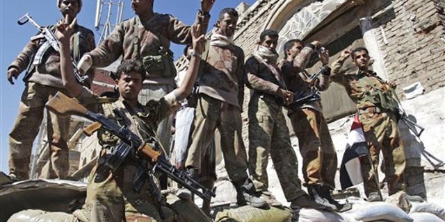 Dec. 25: Yemeni defected army soldiers gesture at protesters marching to demand the prosecution of Yemen's President Ali Abdullah Saleh in Sanaa, Yemen.