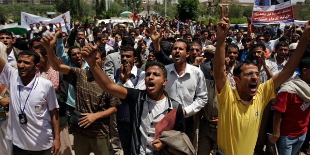 Students shout slogans as they protest on the Sanaa University campus to show their support for a boycott of university studies as part of protests demanding the resignation of Yemeni President Ali Abdullah Saleh, in Sanaa,Yemen, Sunday, Sept. 18, 2011.