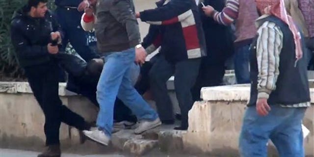 Dec. 30, 2011: This image made from amateur video and made available by Shaam News Network purports to show a wounded protester carried away by others in Idlib, Syria.