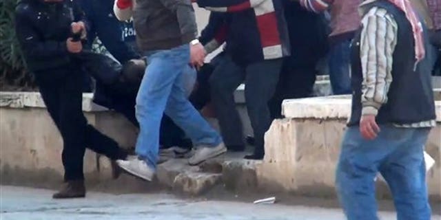 Dec. 30, 2011: This image made from amateur video and made available by Shaam News Network purports to show a wounded protester carried away by others in Idlib, Syria.