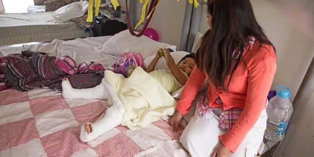 In this Dec. 15, 2015, photo, Marleny Gonzalez, right, looks at her 4-year-old daughter, Jenifer, at a shelter in Reynosa, Mexico, where they are living after trying to cross in to the United States. Gonzalez said her daughter suffered two broken legs when a truck they were traveling in overturned on the journey from Guatemala. âAlmost all my family is in the United States,â Gonzalez said, including her daughterâs father. âI felt alone," she said. Given her daughterâs precarious state, she wasnât sure whether she would make the rest of the trip. (AP Photo/Seth Robbins)