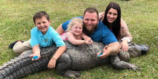 Mike Kliebert and his wife posed with Sally and their two children, each holding blue goo from the gender reveal.