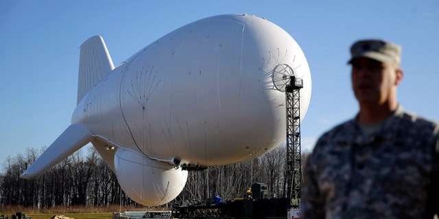 U.S. Air Force Col. William Pitts stands in front of an unmanned aerostat Wednesday, Dec. 17 in Middle River, Md.