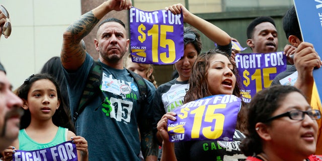FILE - In this Tuesday, July 21, 2015 file photo, workers hold a rally in Los Angeles in support of the Los Angeles County Board of Supervisors' proposed minimum wage ordinance. On Saturday, March 26, California legislators and labor unions reached an agreement that will take the state's minimum wage from $10 to $15 an hour. (AP Photo/Nick Ut)