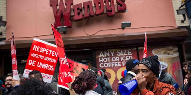 NEW YORK, NY - DECEMBER 05: Protesters rally outside of a Wendy's in support of raising fast food wages from $7.25 per hour to $15.00 per hour on December 5, 2013 in the Brooklyn borough of New York City. A growing number of fast food workers in the United States have been staging protests outside restaurants, calling for a raise in wages, claiming it is impossible to live resonably while earning minimum wage. (Photo by Andrew Burton/Getty Images)
